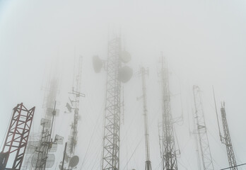antenna towers covered with fog in mountain. Telomoyo, Central Java, Indonesia. electric and...