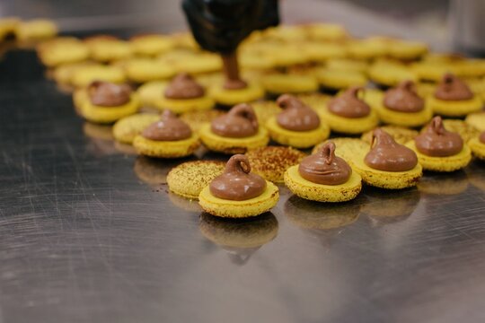 Macaroons with cream on baking pan
