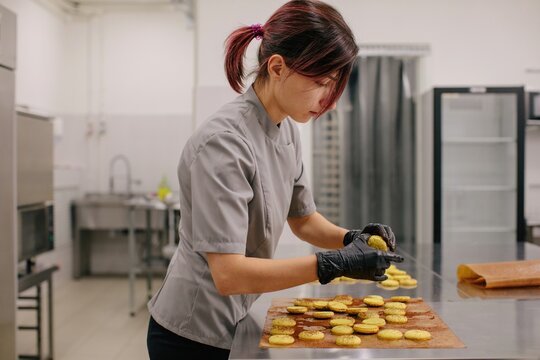 Woman confectioner making macaroons