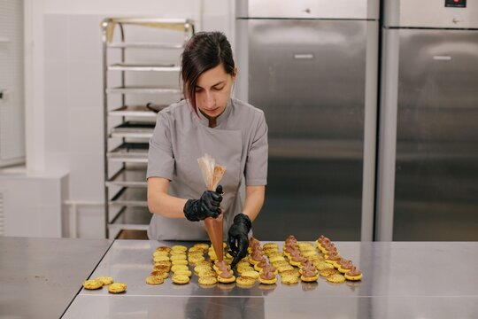 Woman Chef Making Macaroons In Kitchen 