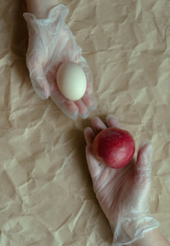 Conceptual still life, hands, egg, apple.