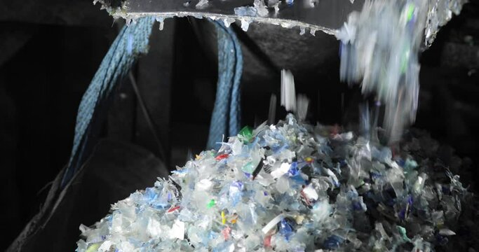 Plastic shredder. Recycling. Close-up of waste shredding process. Fraction. A bag full of shredded plastic. Environmental protection concept.