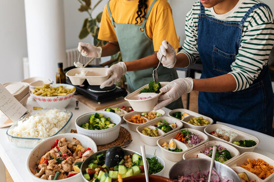 Women preparing food containers to deliver