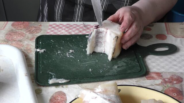 the chef cuts a cod fish with a knife 