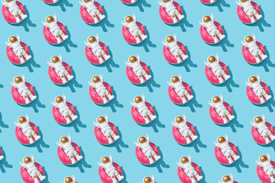 Multiple toy cosmonauts lying on donuts