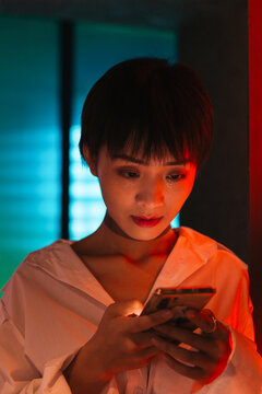 Young woman using the phone in the warm and cold light