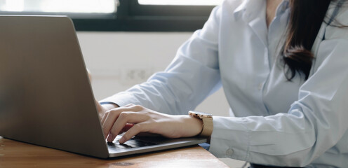 Close up young business women hands using laptop computer in home office