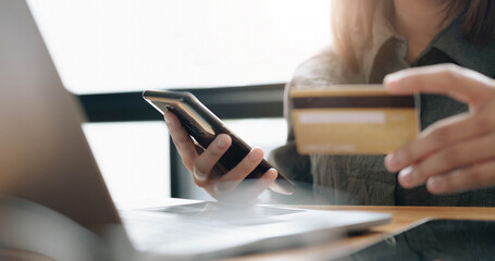 Online payment,woman's hands holding smartphone and using credit card for online shopping. Cyber Monday Concept