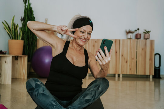 Mature woman in yoga clothes making selfie
