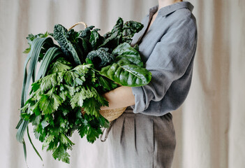 Anonymous female holding basket of greenery
