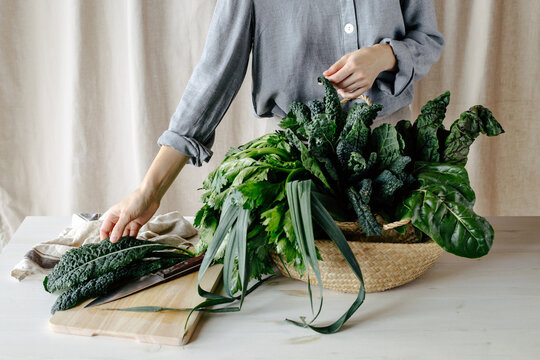 Woman selecting leaf of kale for cooking