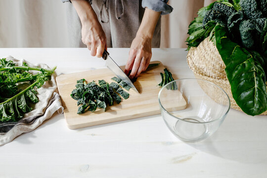 Crop woman cooking green salad