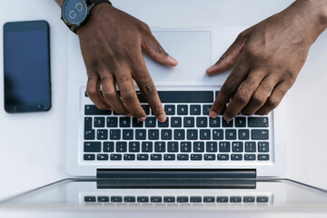 Man typing on laptop keyboard