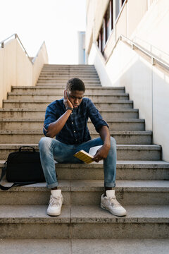 Pensive student reading book in campus