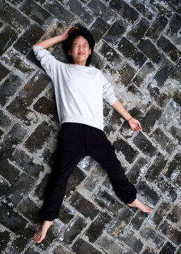 Asian little girl laying on brick floor background