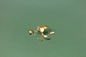 Broken golden bauble on green background