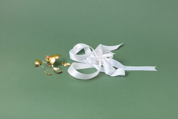 Broken bauble and ribbon on green background