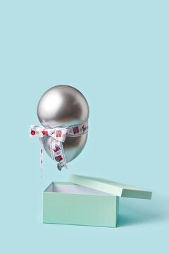 Balloon with ribbon flying over box