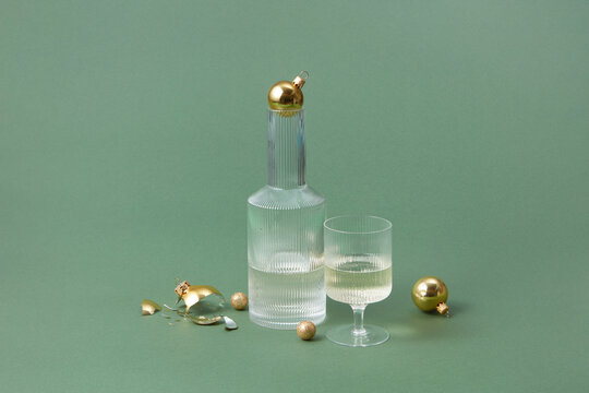 Decanter and glass of champagne on green background