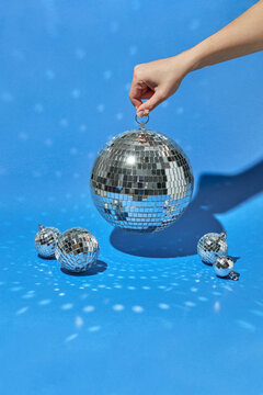 Female hand holding mirror disco ball