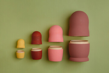 Three wooden dolls lined up on light green paper background