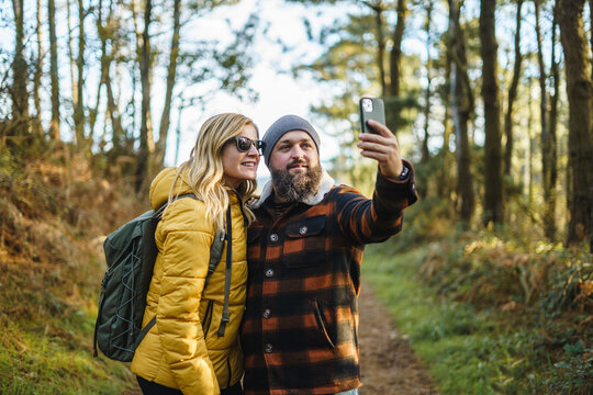 Content couple taking selfie in woods