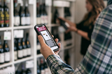 Man Reads Wine App While Shopping