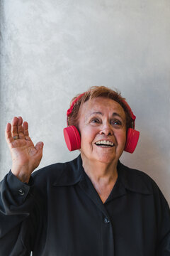 Senior Woman with Red Headphones Listening to Music