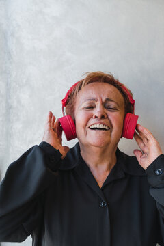 Senior Woman Singing while Holding Headphones