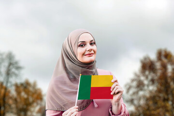 Muslim woman in hijab holds flag of Benin