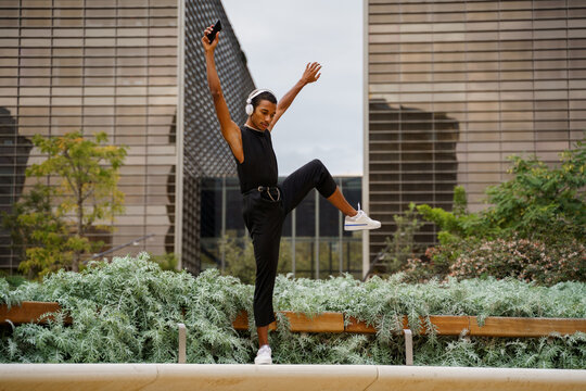 Stylish man dancing in front of office building