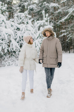 A couple is walking in the snow.