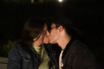 teenage couple kissing passionately on a romantic date in the park at night