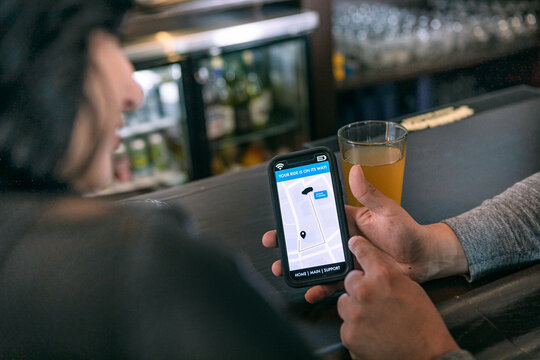 Brewery: Couple Using Cell Phone To Order Rideshare From Bar