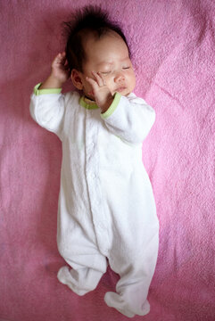 Asian newborn baby on pink background

