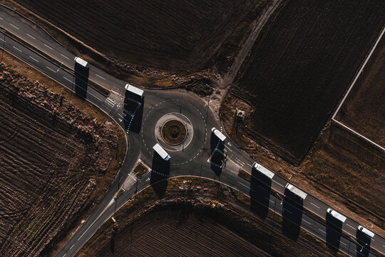 White delivery trucks and vans in roundabout 