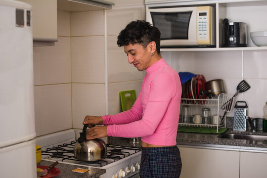 Smiling non binary person making tea