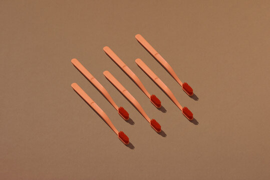 A row of toothbrushes on a brown background