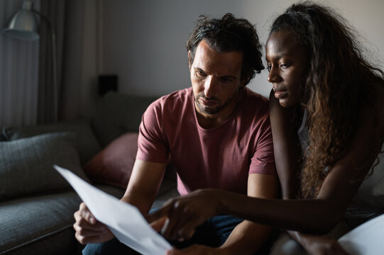 Diverse couple with debts at home