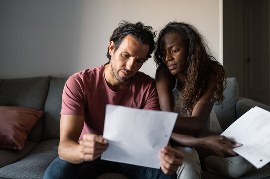 Diverse couple with debts at home