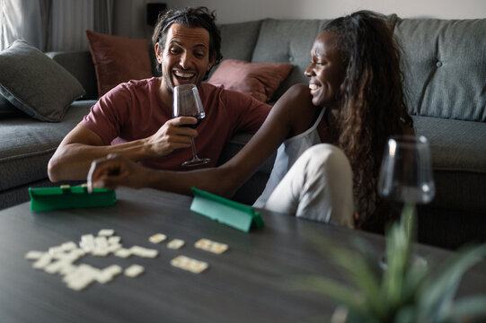 Smiling diverse couple playing board game