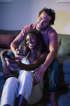 Positive diverse couple watching TV