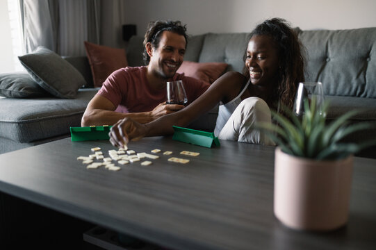 Smiling diverse couple playing board game