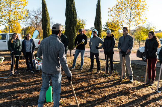 Volunteer group leader explaining how to plant a tree