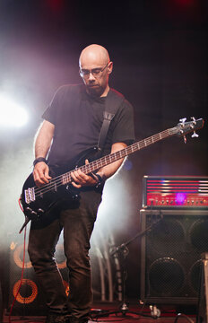 Bald musician playing bass during live concert