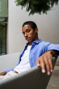 Portrait of confident man sitting on bench in the city