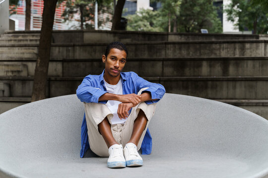 Portrait of confident man sitting on bench in the city