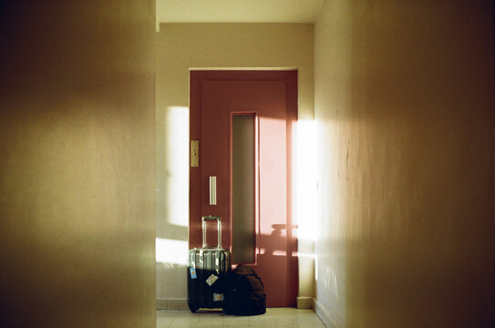 Luggage and backpack in front of the lift door before a trip