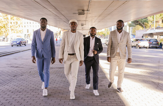 Black men in suits walking on the street