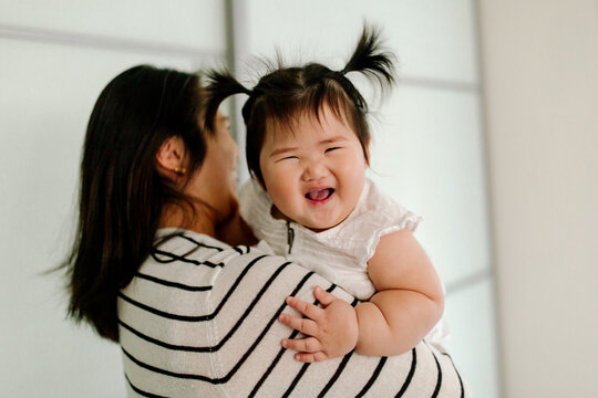 Laughing Asian baby with whale spout hair